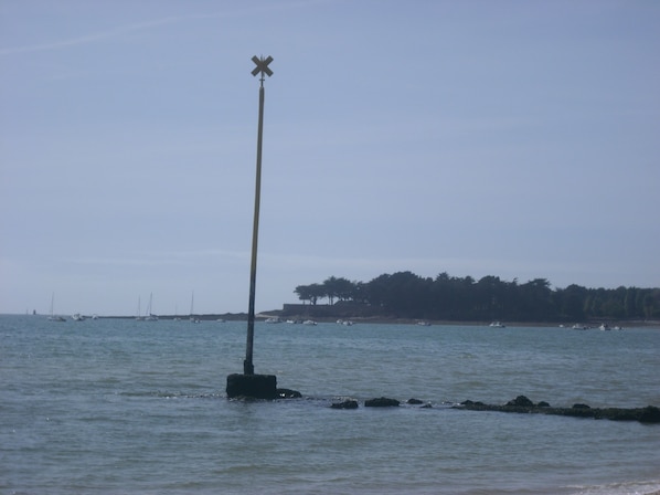 A lighthouse by the sea with a clear sky.