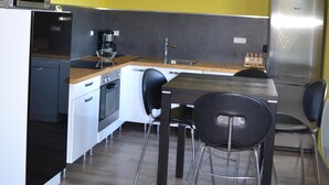 A compact kitchen with a microwave, coffee maker, and refrigerator. - Gîte with view of the Chaîne des Puys - 4 pers - large garden - near Vulcania (Landogne)