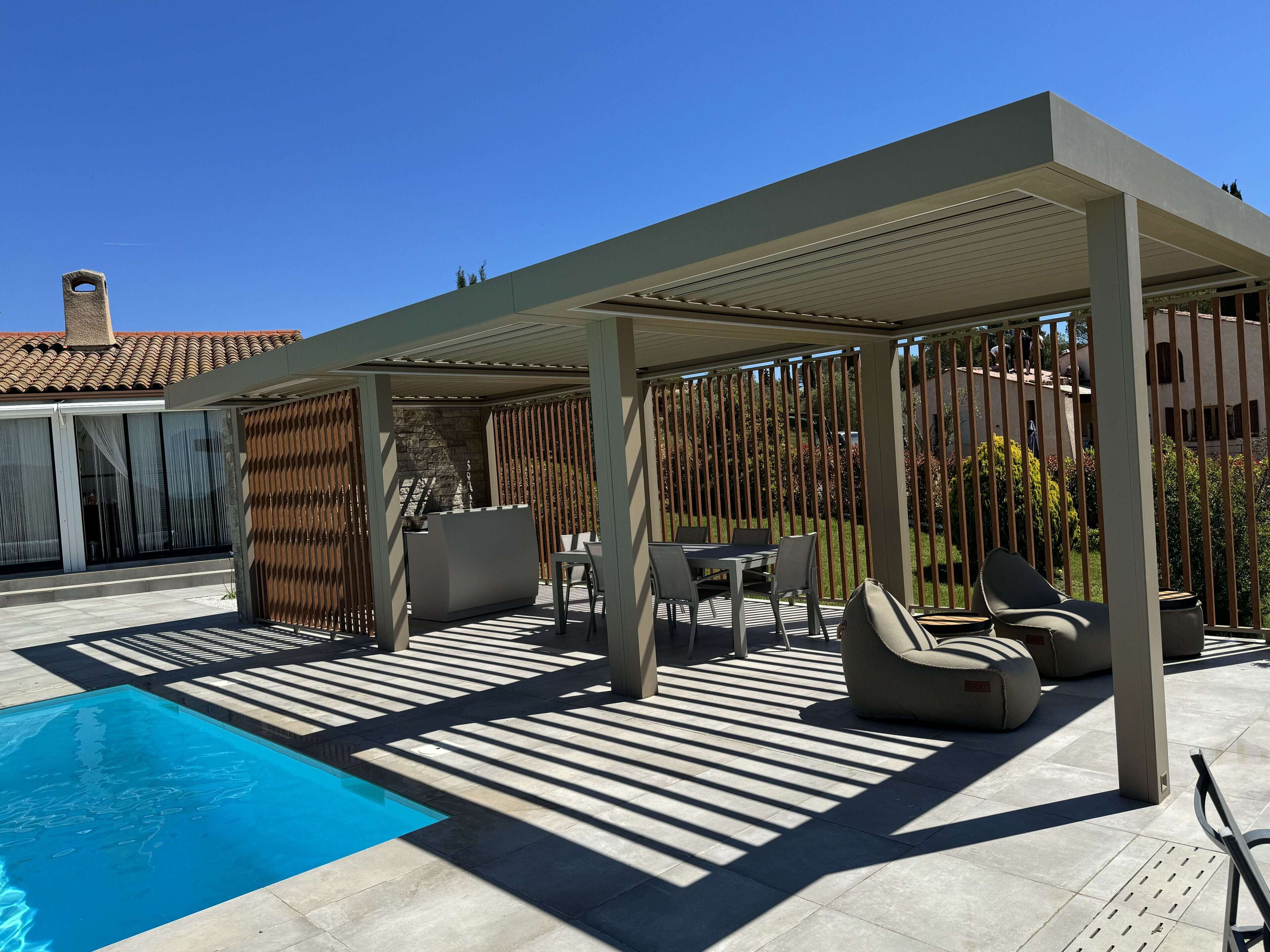 Ett takförsett utomhusområde med en pool, sittplatser och en pergola.