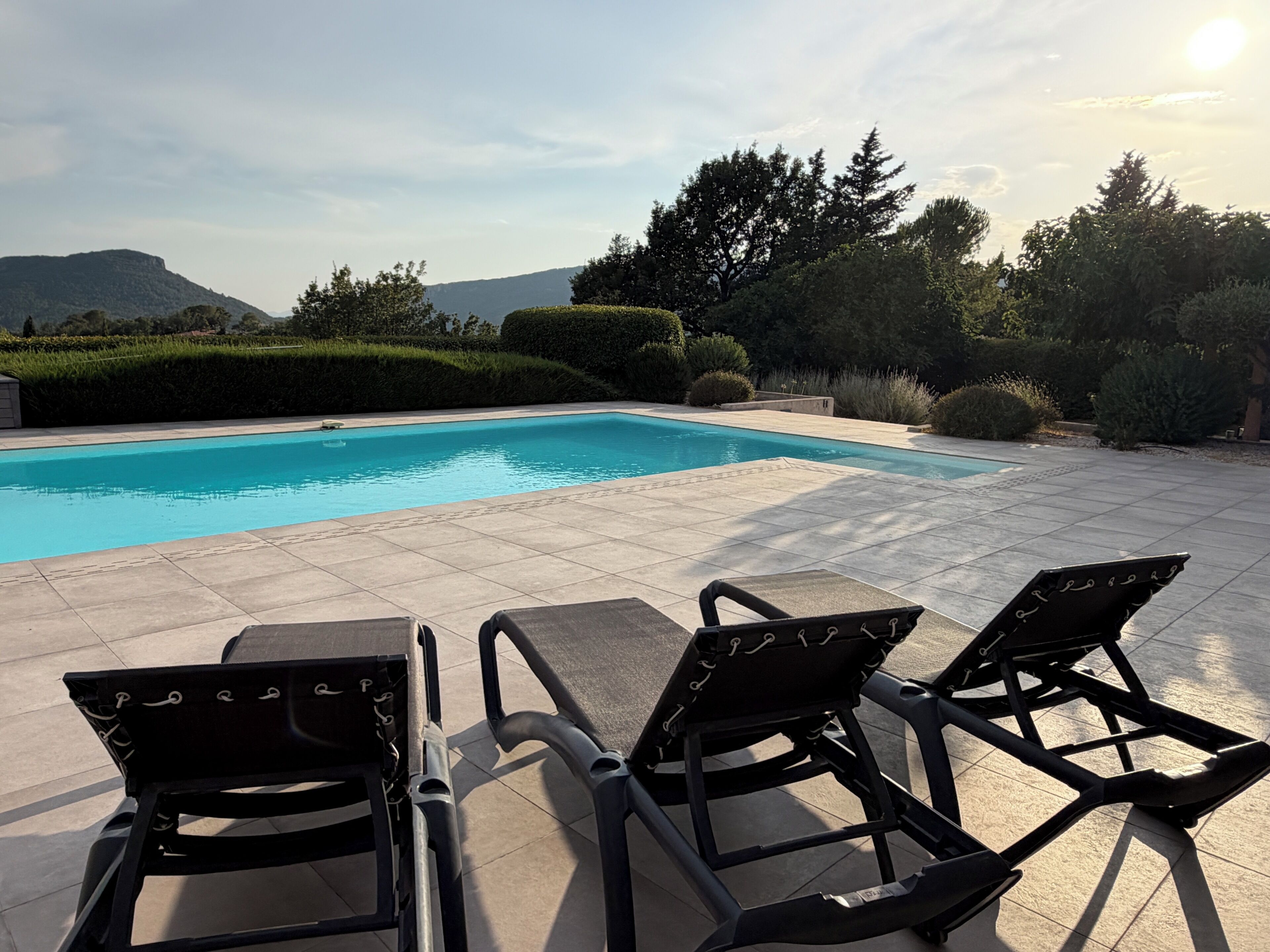 Une piscine dotée de chaises longues et offrant une vue sur le paysage environnant.
