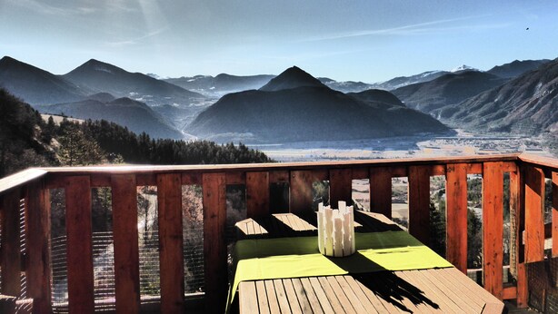 A wooden deck with a table and chairs overlooking a mountainous landscape. - Beautiful duplex of 110 m² in a chalet style Full of charm, awarded 3 stars (Théus)