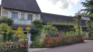 A stone building with a sign reading "Les Nymphées Restaurant - Salon de The". - The closeau du cèdre in Normandy between Paris and Rouen, near Giverny (Ménilles)