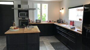Una cocina moderna con una isla central, electrodomésticos integrados y un amplio ventanal que proporciona luz natural.
