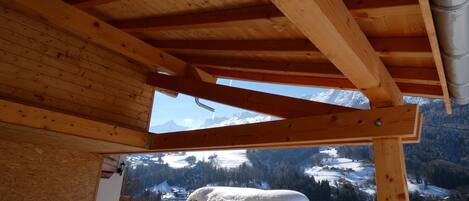 A wooden ceiling structure with a view of a snowy mountain landscape.