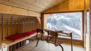 A wooden cabin interior with a bench, a table, and a view of a snowy mountain landscape. - Chalet Haute Savoie quiet jacuzzi wifi near Lake Annecy (Thônes)