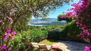 Un patio con mobiliario exterior y vistas a un lago y colinas.