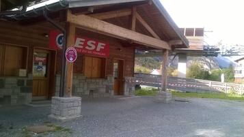 Een houten gebouw met een bord waarop 'ESF' en 'LECOLES PRIVEES' staat.