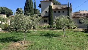 A traditional building with a tiled roof, surrounded by olive trees and a grassy area. - Charming farmhouse in a 5000m2 field, private swimming pool, beach 200m away (Sainte-Maxime)