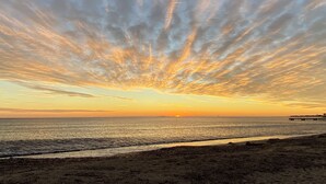 A beach with a sunset and a pier in the distance. - Charming farmhouse in a 5000m2 field, private swimming pool, beach 200m away (Sainte-Maxime)