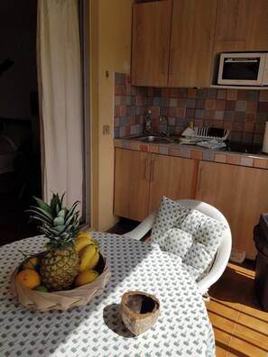 Enjoy meals in this cozy kitchen with a dining table and chair, microwave, and a convenient fruit basket.