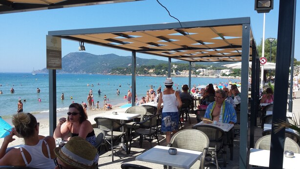 A beachside café with outdoor seating overlooking the sea.