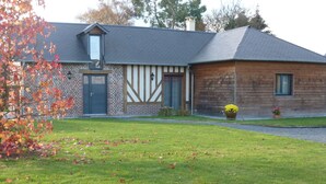 A two-story building with a brick facade and a wooden extension.