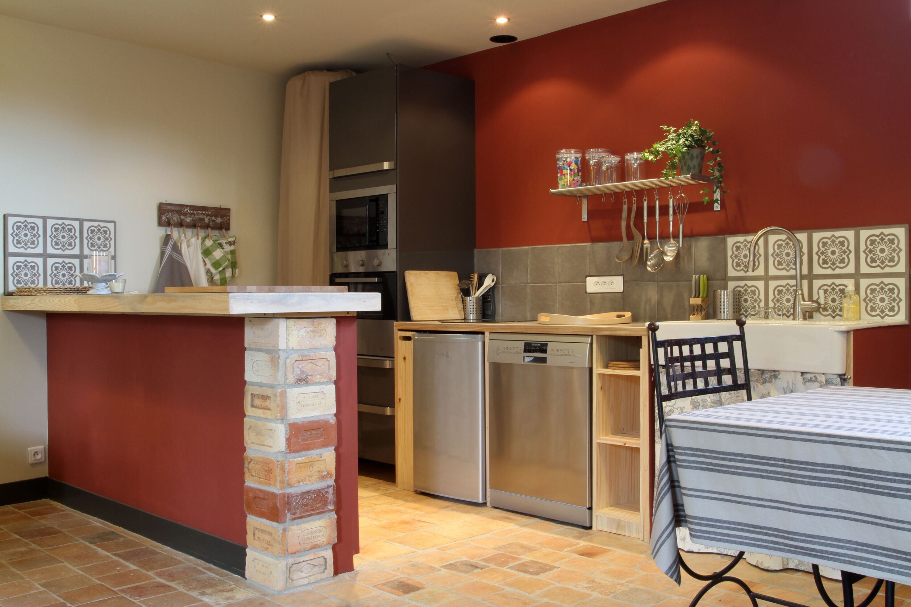A compact kitchen with a brick column, a built-in oven, and a dishwasher.