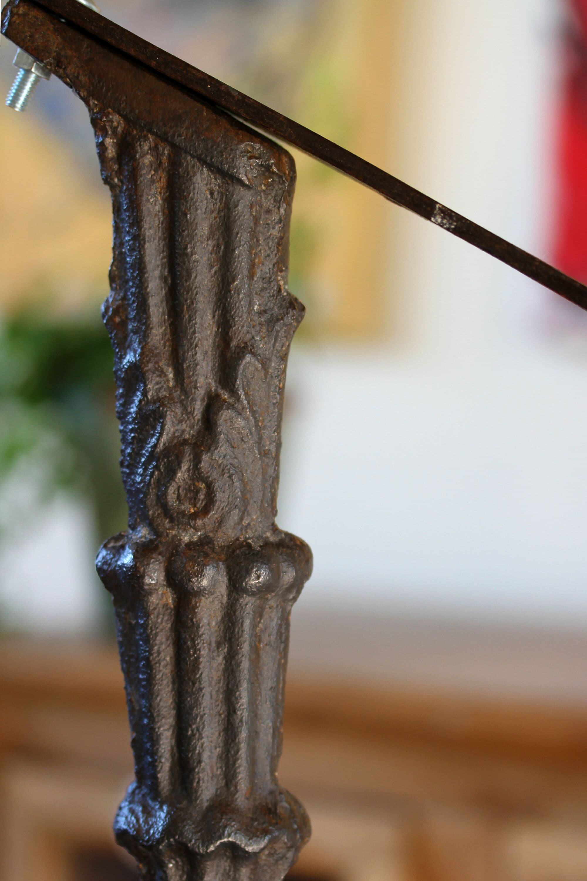 Een close-up van een metalen constructie met een schroef en een horizontale stang.