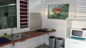 Een kleine keuken met een spoelbak, een magnetron en een klein aanrecht.