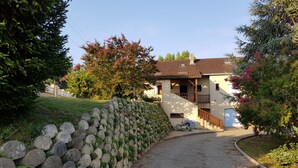 A house with a stone wall, a gravel driveway, and a wooden staircase leading to the entrance. - Charming holiday home with private heated pool (Prayssac)
