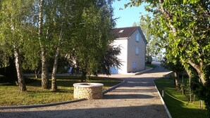 A building with a tiled roof, surrounded by trees and a gravel path leading to it. - Charming holiday home with private heated pool (Prayssac)