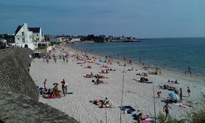 A beach with people sunbathing and swimming. There is a hotel with a sign visible in the background. - Appart.Standing ***, sea view, 2/4 Pers.Piscine chauffée.Wifi (Concarneau)