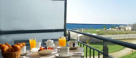 Balcón con preparación para desayuno con vistas a la costa.