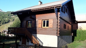 A wooden house with a balcony, a staircase, and a view of a mountainous landscape. - Very pretty semi-detached chalet, all comforts, close to the Chantemerle slopes  (Saint-Chaffrey)