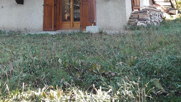 A wooden chalet with a balcony, a wooden door, and a staircase leading to the upper floor. - Very pretty semi-detached chalet, all comforts, close to the Chantemerle slopes  (Saint-Chaffrey)