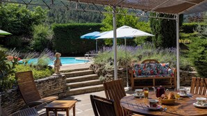 An outdoor patio with a pool, stone steps, wooden furniture, and umbrellas. - Nyons, charming villa in a green setting  (Nyons)