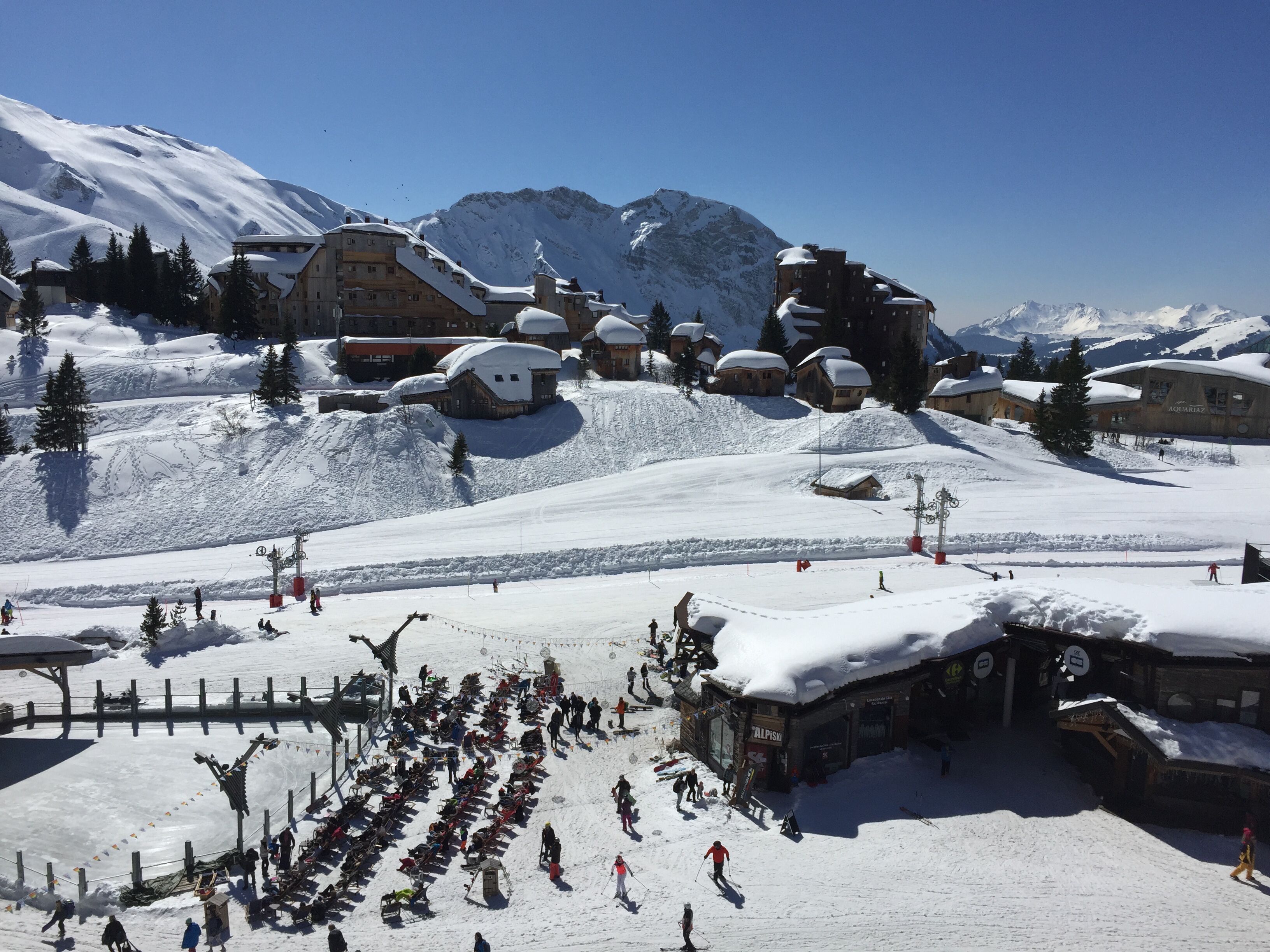 A snow-covered ski resort with multiple buildings, including a lodge and a restaurant.