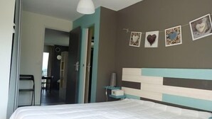 A bedroom with a bed, a bedside table, and a wall with heart-shaped decorations. - Cottage at the Mirande farm near Rocamadour, Padirac, Collonges la rouge (Queyssac-Les-Vignes)