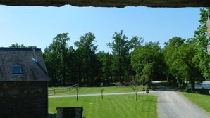 A rural setting with a gravel road, a stone building, and a grassy area with trees. - Gîte for 6 people with heated indoor pool - Gîtes de France 5 épis (Carentoir)