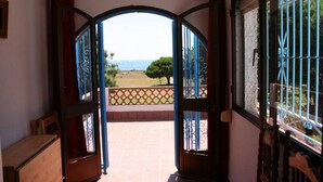 A doorway leading to a balcony with a view of the sea. - Villa MALYMA direct beach access (Zahora)