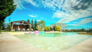 A swimming pool with lounge chairs and a wooden structure in the background. - Exclusive Hamlet and XXL Pool (Vergt)