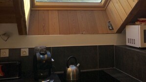 Een keuken met dakraam, waterkoker en koffiezetapparaat.