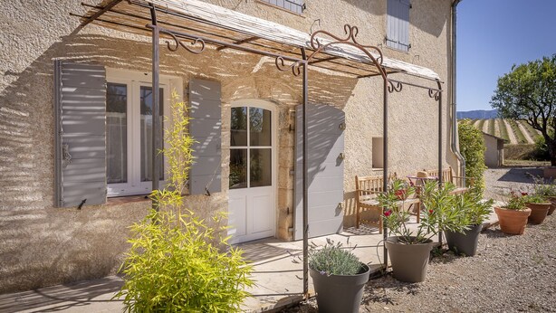 A rustic stone building with a covered patio, potted plants, and a wooden table and chairs. - Farmhouse in the middle of the Provence  (Moustiers-Sainte-Marie)