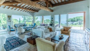 Amplia sala de estar con techo alto, ventanas grandes y vistas al exterior.
