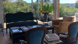 Un patio amplio con techo de madera, un sofá, dos sillones, una mesa de centro y una planta en maceta.