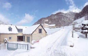 A snow-covered village with traditional buildings and a mountain backdrop. - CAUTERETS Chalet La Grange (sleeps 2–11) in a quiet neighborhood, with parking (Cauterets)
