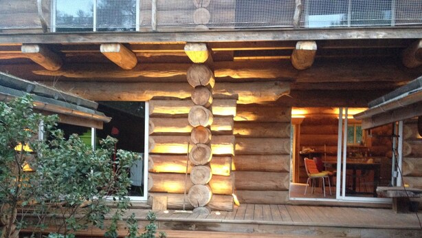 Eine Blockhütte mit einer Treppe, die zu einer Veranda führt.