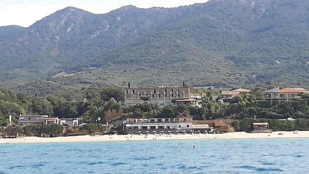 A coastal hotel with multiple buildings, a beach, and mountains in the background. - RENT STUDIO 30 m² fully equipped  (Coggia)