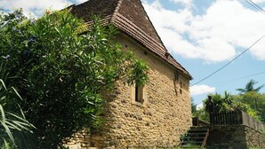 A rustic stone building with a steeply pitched roof and a small window. - Charm & Tranquility in the heart of Périgord Noir with private heated pool (Le Bugue)