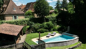 A backyard with a swimming pool, a wooden deck, and a small shed. - Charm & Tranquility in the heart of Périgord Noir with private heated pool (Le Bugue)