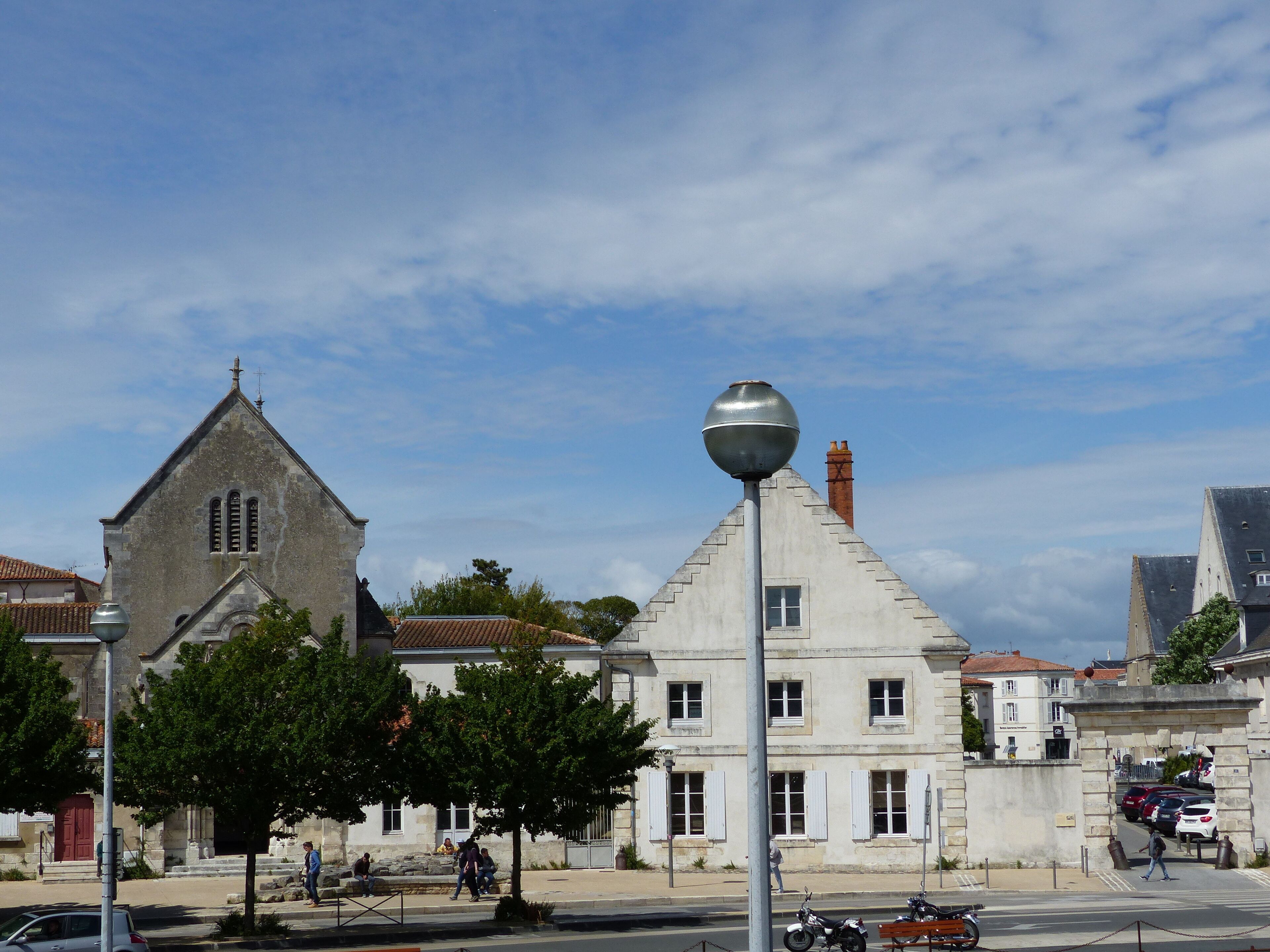 A historic building with a prominent tower and a spherical street lamp.