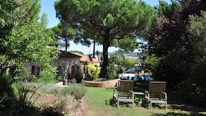 A house with a large tree in the backyard, two wooden chairs, and a patio area. - GASSIN, 6 km from Saint-Tropez, exceptional villa for 8 people (Gassin)