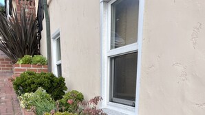 A row of potted plants along a brick pathway next to a building with a window. - Studio 2 blocks to Beach w/ Parking - Close to LAX (Manhattan Beach)