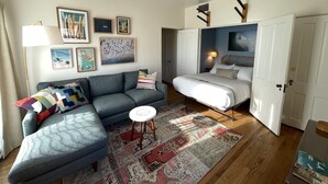 A modern living room with a grey sofa, a patterned rug, and a ceiling fan. - Studio 2 blocks to Beach w/ Parking - Close to LAX (Manhattan Beach)