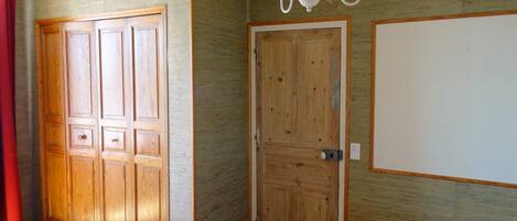 A room with wooden doors, a chandelier, and a red curtain.