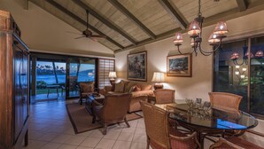 A spacious dining area with a glass table, wicker chairs, and a ceiling fan. - Napili Lani 320 2BD Luxury with Beach Access (Lahaina)