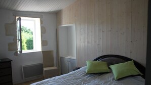Une chambre à coucher avec un lit, une chaise, une armoire et une fenêtre.