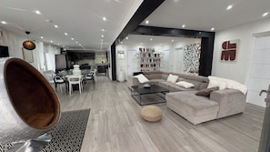 Un salon moderne avec un canapé, une table basse et un coin repas.