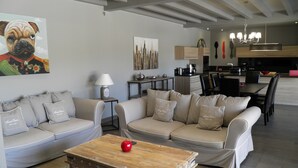 Ein modernes Wohnzimmer mit einer Sofagarnitur, einem Couchtisch und einem Essbereich mit Stühlen und Tisch.
