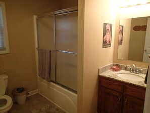 Bañera con ducha, secador de pelo, toallas, papel higiénico